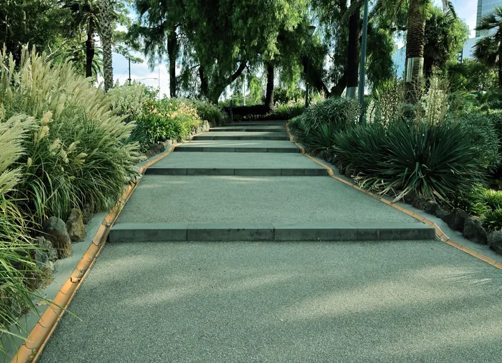 Wide stone steps with dense plantings on both sides, used as general hardscape atmosphere.